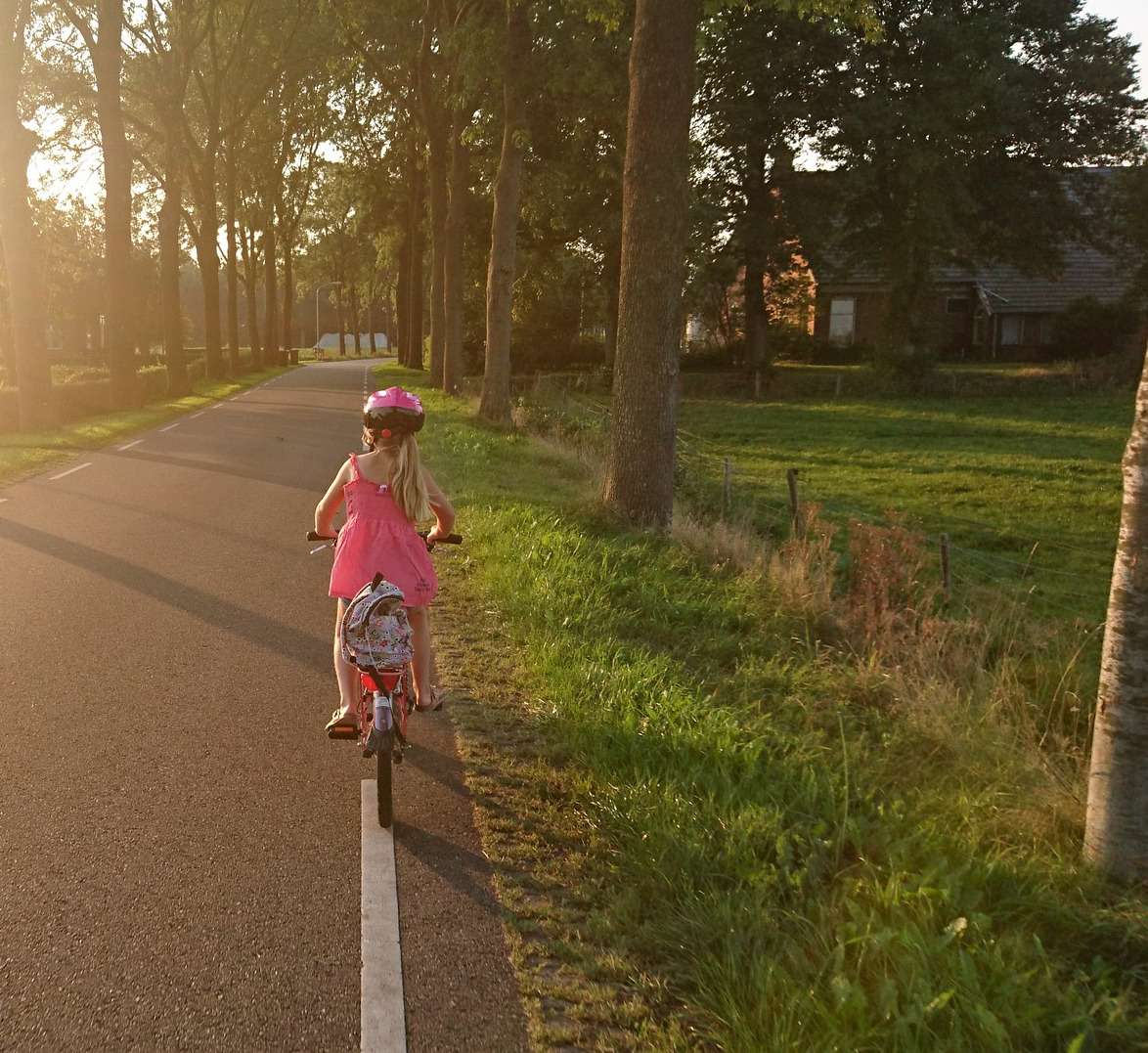 Kind auf Fahrrad auf dem Weg zur Schule im Straßenverkehr